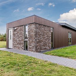 Gemuetliches Wohnzimmer im 8-Personen-Ferienhaus Sallandse Heuvelrug, Hoge Hexel, mit Blick auf die Natur.