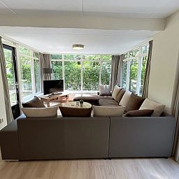 Gezellige woonkamer in bungalow Vuurvlinder met Serre 10, Hoge Hexel, Twente. Ruime zithoek met uitzicht op de groene natuur van Overijssel.