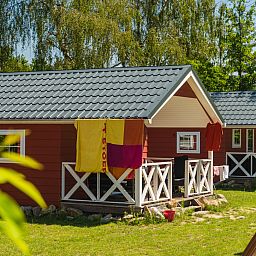 Summer sun on Scandinavian lodge in Zuna, vacation home surrounded by green nature in Twente, Overijssel.