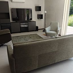 Cozy living room in Cottage in Buurse, vacation home in Twente, with comfortable seating and large windows.