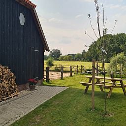 Buitenruimte van Vakantiehuisje in Hengevelde, Twente met picknicktafel en landelijke omgeving.