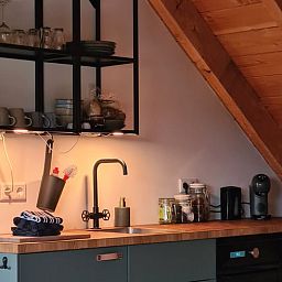 Compacte keuken in Vakantiehuisje in Hengevelde, Twente met houten details en moderne apparatuur.