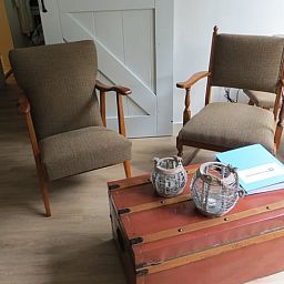 Stilvoller Innenraum im Ferienhaus in Boekelo, Enschede, mit bequemen Stuehlen und einer rustikalen Truhe.