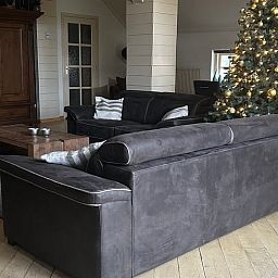 Gemuetlicher Innenbereich des Ferienhauses in Goor, Twente, Overijssel mit stimmungsvollem Esstisch und Weihnachtsbaum fuer eine heimelige Atmosphaere.