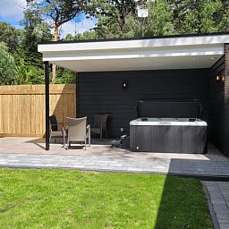 Ontspan op het terras van Vakantiehuis in Holten, Salland, Overijssel, met een moderne jacuzzi en omringd door rustgevende natuur.