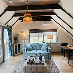 Gezellige woonkamer van Vakantiehuisje in Wijhe, Salland met comfortabele bank en eetruimte.
