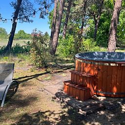 Entspannen Sie sich auf der Terrasse des Ferienhauses in Haarle, umgeben von gruenen Waeldern in Hellendoorn, Overijssel.