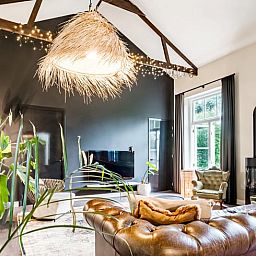 Gezellige binnenruimte in Vakantiehuis in Diepenveen, met sfeervolle verlichting en comfortabele zitplaatsen.