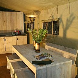 Geraeumiges Wohnzimmer der Summer Lodge Glamping Lodge in Beerze, Overijssel, mit gemuetlicher Sitzecke.
