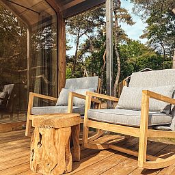 Bequeme Stuehle auf der Veranda des Wikkelhouse XL in Beerze, umgeben von der ruhigen Natur der Overijssel.