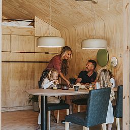 Family enjoys meal in Wikkelhouse vacation home in Beerze, Vechtstreek, Overijssel.