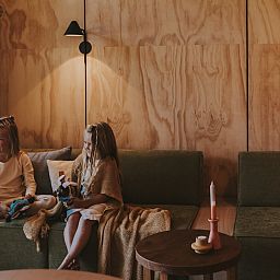 Children relax in the sitting area of Wikkelhouse glamping lodge in Beerze, Overijssel.