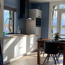 Dining area in Holiday Home in Dalfsen, Overijssel, with large window overlooking the Vecht region and the water.