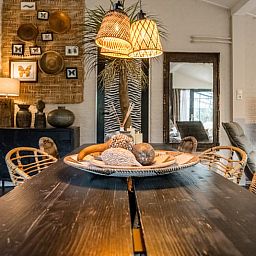 Esstisch im Ferienhaus in Rheezerveen, Vechtstreek, Overijssel mit dekorativen Accessoires und warmer Beleuchtung.