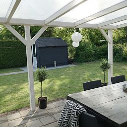 Rustikaler Garten des Ferienhauses OV649 in Rheezerveen, Vechtstreek, Overijssel, mit gruener Hecke und Weg zur Entspannung in der Natur.