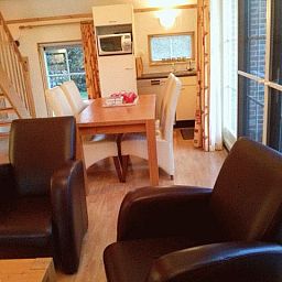 Gezellige woonkamer van vakantiehuis AA-Reestryck in IJhorst, Overijssel, met comfortabele stoelen en eetruimte.