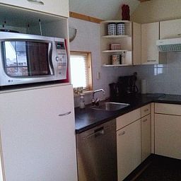 Moderne keuken in vakantiehuis AA-Reestryck, IJhorst, Noordwest Overijssel met magnetron en vaatwasser.