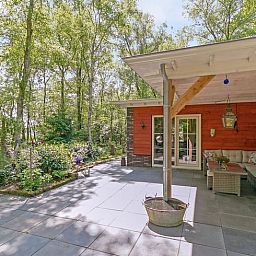 Comfortabele zithoek op het terras van Vakantiehuis in Bergentheim, omgeven door bomen in de Vechtstreek, Overijssel.