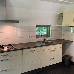 Moderne Kueche im Ferienhaus in Lemele, Vechtgegend Overijssel, mit stilvoller Einrichtung und Blick auf die gruene Natur.