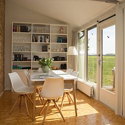 Lichte eetruimte in Vakantiehuisje in Stegeren met uitzicht op de natuur van de Vechtstreek.