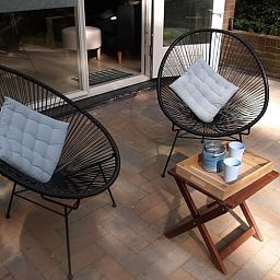 Geniessen Sie die Terrasse des Ferienhauses in Stegeren, Vechtstreek, Overijssel, mit bequemen Stuehlen und einem gemuetlichen Tisch.