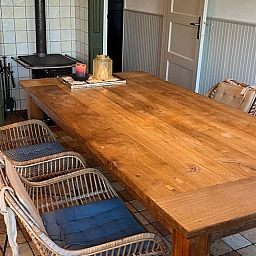 Gezellige eetkamer in Vakantiehuisje in Den Velde, Overijssel, met rustieke houten tafel en sfeervolle inrichting in de Vechtstreek.