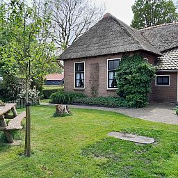 Beautiful garden at vacation home OV602 in Giethoorn with picnic table and green surroundings.