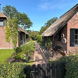 Zwei Ferienhaeuser in Giethoorn mit gruenem Garten in Overijssel.