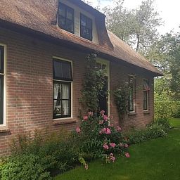 Authentiek bakstenen Vakantiehuisje in Giethoorn omgeven door groen in Noordwest Overijssel, Overijssel.