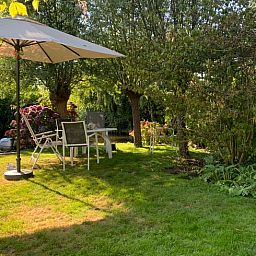 Ruhiger Garten bei Huisje in Giethoorn, Ferienhaus im Nordwesten von Overijssel mit schattigem Sitzbereich und gruener Umgebung.