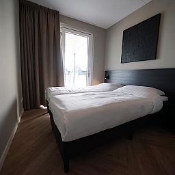 Gemtliches Schlafzimmer in einer Wohnung in Kampen, Nordwest-Overijssel, mit bequemem Doppelbett und Blick auf die Terrasse.