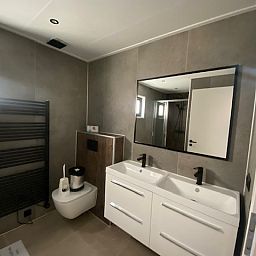 Modern bathroom in the detached house in Kampen, Overijssel, equipped with double sink and spacious mirror.