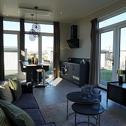 Stijlvolle woonkamer in de Vrijstaande woning in Kampen, Overijssel, met grote ramen en modern interieur.