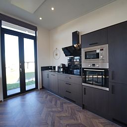 Moderne keuken in de Vrijstaande woning in Kampen, Noordwest Overijssel, met uitzicht op de tuin. Perfect vakantiehuis voor culinaire liefhebbers.