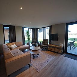 Cozy living room in the detached house in Kampen, Northwest Overijssel, with modern furnishings and a view of the garden.