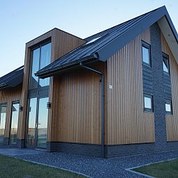 Modernes Einfamilienhaus in Kampen, Overijssel, mit Holzfassade und groen Fenstern, ideales Ferienhaus im Nordwesten von Overijssel.