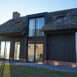 Vrijstaande woning in Kampen, Noordwest Overijssel, vakantiehuis met rieten dak en moderne architectuur, omgeven door groene omgeving.
