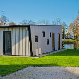 Moderne vrijstaande woning in Kampen, Overijssel, omringd door groene natuur en rustgevende waterkant.