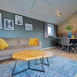 Stijlvolle woonkamer in vrijstaande woning in Kampen, Noordwest Overijssel, met moderne inrichting en kunst aan de muur.