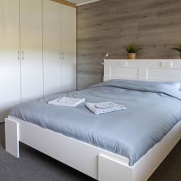 Gemuetliches Wohnzimmer im Ferienhaus OV700, Scheerwolde, mit bunten Kissen und Blumen in Overijssel.