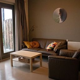 Lichte woonkamer in Huisje in Steenwijk, vakantieaccommodatie in Overijssel, met uitzicht op tuin en stijlvolle inrichting.