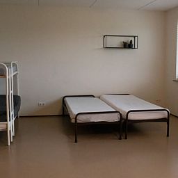 Ruime slaapkamer in Huisje in Steenwijk, Overijssel, met stapelbed en twee eenpersoonsbedden voor een ontspannen verblijf.