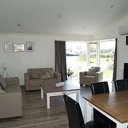 Gezellige woonkamer in de vrijstaande woning in IJhorst, Overijssel, met uitzicht op de tuin en comfortabele zithoek.