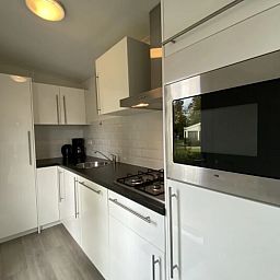 Moderne keuken in de Vrijstaande woning in IJhorst, vakantiehuis in Noordwest Overijssel, Overijssel, met strakke inrichting en apparatuur.