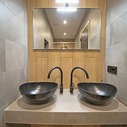 Modernes Badezimmer in einem freistehenden Haus in IJhorst, Overijssel, mit stilvollem Doppelwaschbecken und Spiegel.