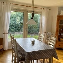 Dining room of Holiday home in IJhorst overlooking green garden, ideal for cozy meals.