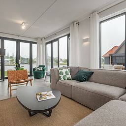 Moderne woonkamer in Watervilla 8, vakantiehuis in Ossenzijl, Noordwest Overijssel, met ruime zithoek en veel natuurlijk licht.