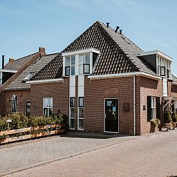 Cozy living room of OV684 vacation home in Blokzijl, with flowers and comfortable sofa, Northwest Overijssel.