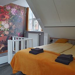 Attractive bedroom in OV684 vacation home, Blokzijl, with colorful flower wallpaper, Northwest Overijssel.