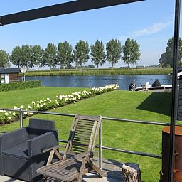 Terras bij Huisje in IJsselmuiden met uitzicht op de rivier, perfect voor rust in Overijssel.